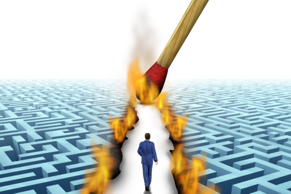 Leader Solutions with a businessman walking through a complicated maze opened up by flames and fire lit by a match as a business concept of innovative thinking for financial success.